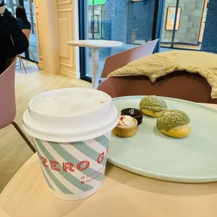a cup of coffee and donuts on a table