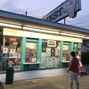 a woman walking in front of an ice cream shop