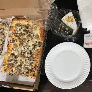 Doppio zero pizza and pistachio cake. They include plates, red pepper, Parmesan, a billion napkins, forks and knives.