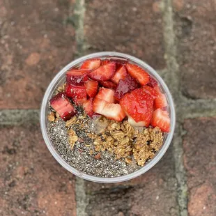 strawberries and granola in a plastic cup
