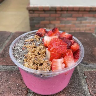 a pink smoothie with strawberries and granola