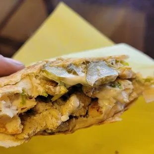 a hand holding a chicken quesadilla