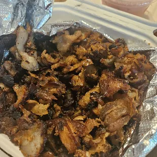 Crumbs. Dried out little pieces of pork,  cooked to their death.  Not at all edible.  Looks like bottom of the pan,  end of night garbage.