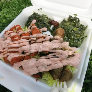 Combo plate with double spinach. Orange tzatziki sauce over meat and spicy sauce on the side.