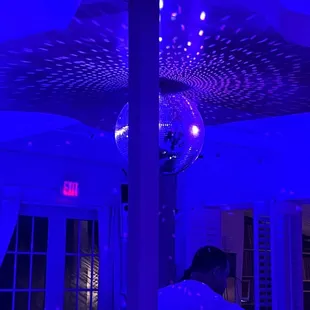 a man standing under a disco ball