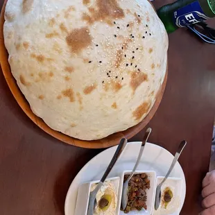 a large flat bread and a small bowl of dips