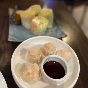 a plate of dumplings and dipping sauce