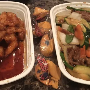 two takeout containers of chinese food