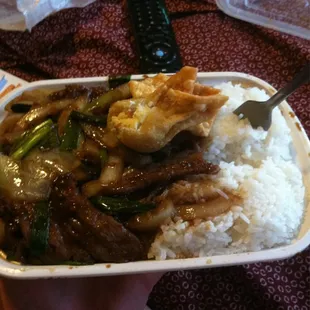 a hand holding a container of food