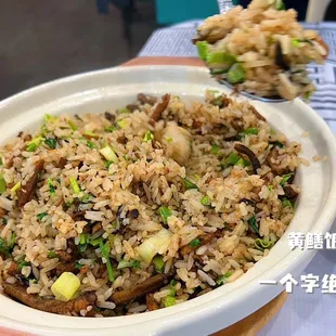 a bowl of rice with mushrooms and scallions