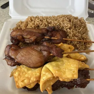 a white styrofoam container with meat skewers and rice