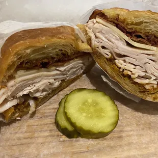 a cut in half sandwich and a pickle