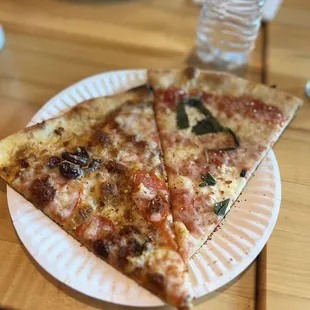 two slices of pizza on a paper plate