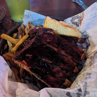 1/2 Rack Rib Basket with side of hand-cut fries and garlic bread.