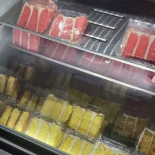 Cake Case: Strawberry Crunch Cake, Yellow Cake w/ Chocolate Icing, Lemon Cake, and Birthday Cake.