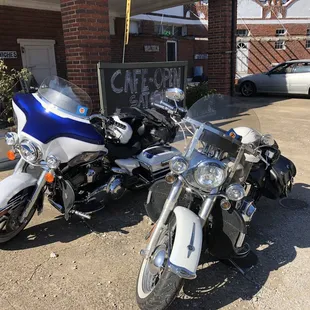 two motorcycles parked in front of a cafe