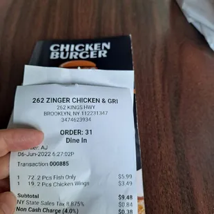 a hand holding a receipt