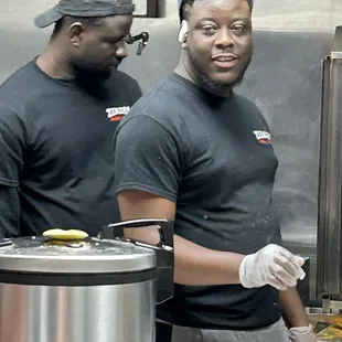 The one smiling is David; he took my order &amp; another half dozen before going to kitchen area &amp; help expedite all client orders!