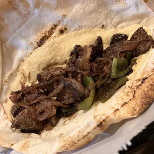 Shish kabob wrap. Tender steak with hummus, peppers, and onions. Shish Kebob Sandwich