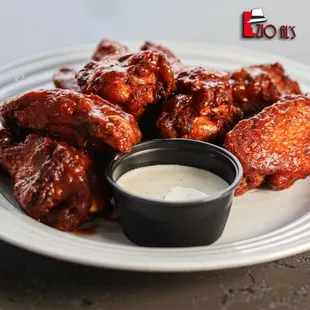 a plate of chicken wings with dipping sauce