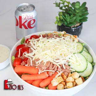 a bowl of salad and a can of coke