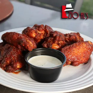 a plate of chicken wings with dipping sauce