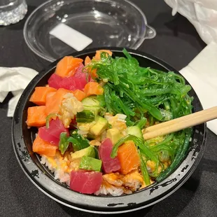 a bowl of sushi with chopsticks