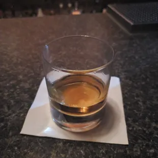 a glass of whiskey on a napkin