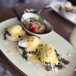 The flight of Benedict&apos;s with a side salad.