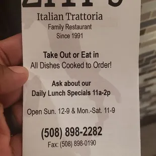 a hand holding a restaurant menu