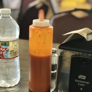a bottle of hot sauce next to a toaster