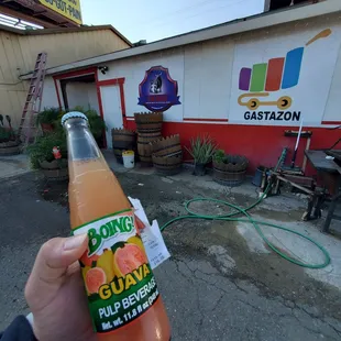 a person holding a bottle of orange juice
