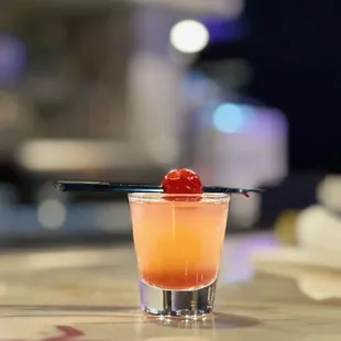 a cocktail with a cherry garnish