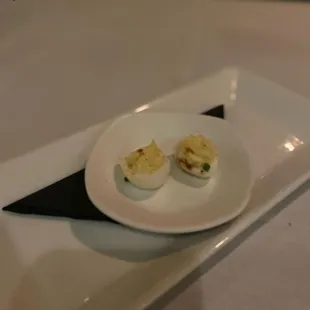 two deviled eggs on a white plate