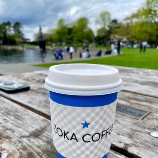 a cup of coffee on a picnic table