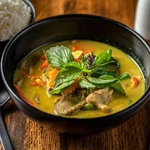 a bowl of soup with rice and chopsticks