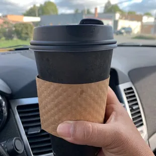 a hand holding a coffee cup