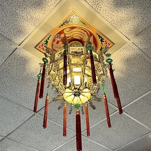 a chinese clock hanging from the ceiling