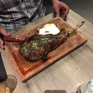 Tomahawk steak served with golden potatoes and egg