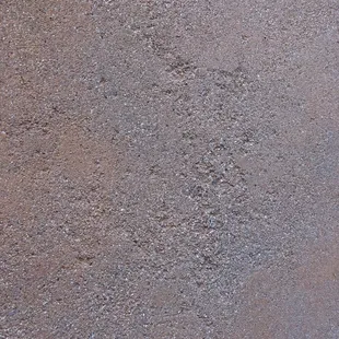 "Sand finish" showing pitting and color variation (photo taken in shade).