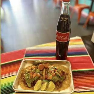 a plate of tacos and a bottle of coke