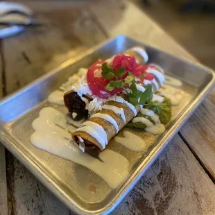 TAQUITOS DORADOS potato, mixed cheese, avocado, queso fresco, pickled onions, crema