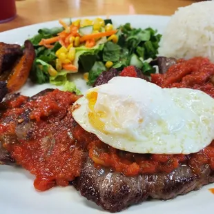 a plate of food with meat, rice, and a fried egg