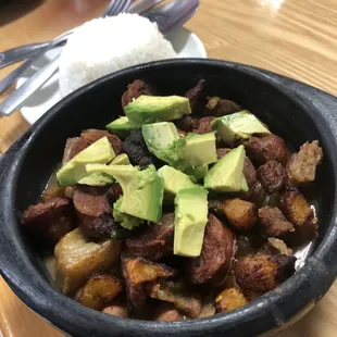 Frijolada - pieces of pork belly and chorizo on top of delicious pinto beans and plantains; fresh avo on top.
