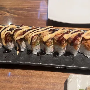 a close up of a sushi roll with sauce on it
