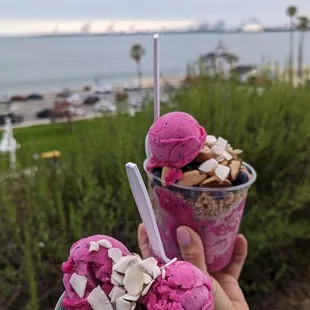  person holding two cups of ice cream