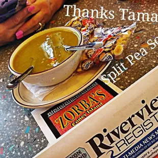 a bowl of soup and a newspaper