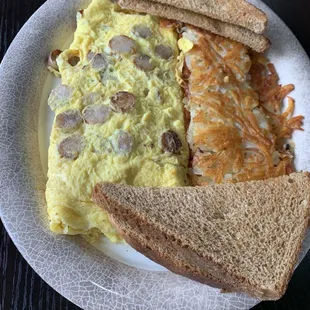 Sausage and egg omelet, hash browns with proper crispness, but off-putting flavor, and wheat toast.