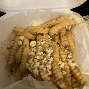 Loaded Greek fries with seasoning salt, Feta and Greek dressing.