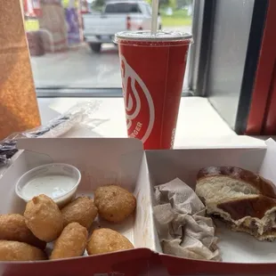 Looking out the window past my Swiss cheese mushroom burger on a pretzel roll, with Mac &amp; cheese bites and drink.